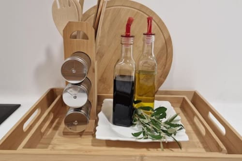 Organizador de cocina de madera con utensilios culinarios, frascos de especias, botellas de aceite de oliva y vinagre balsámico con hierbas frescas en villa