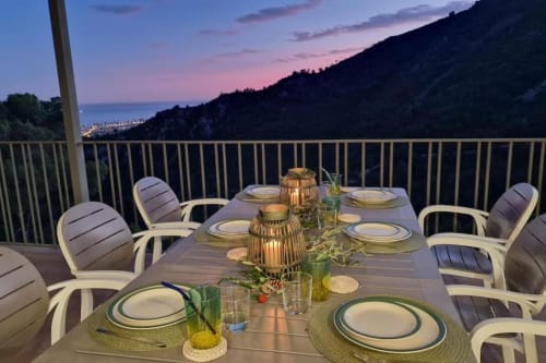 Elegante comida al aire libre en villa de Benicàssim con vistas al mar, montañas de fondo y ambiente de atardecer
