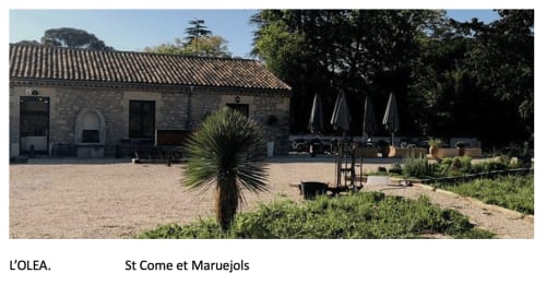 L'OLEA restaurant at La Conciergerie De Franck in Boissieres with stone building and outdoor seating area
