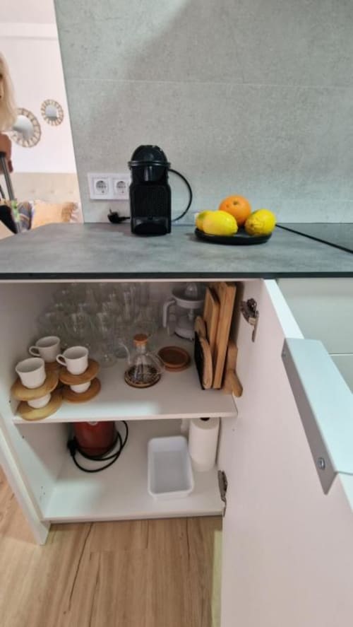 Encimera moderna con cafetera, tazas, utensilios y limones frescos en el apartamento de playa MiramaRent en Benicàssim