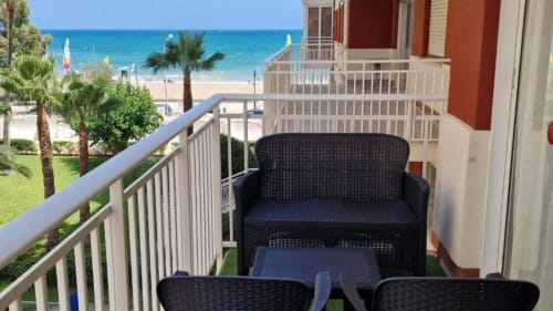 Balcón de apartamento frente al mar en Benicàssim con vistas al océano, muebles de ratán negro y acceso directo a la playa