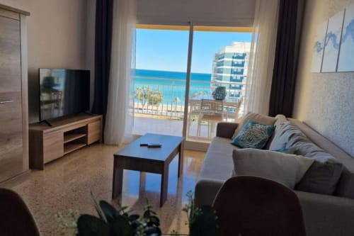 Salón con vistas al mar en MiramaRent Benicàssim, balcón frente a la playa, sofá moderno, TV y ambiente mediterráneo