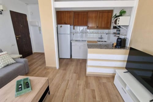 Cocina abierta y salón en el apartamento Sunset de MiramaRent, Benicàssim con suelos de madera y acceso a vistas al océano