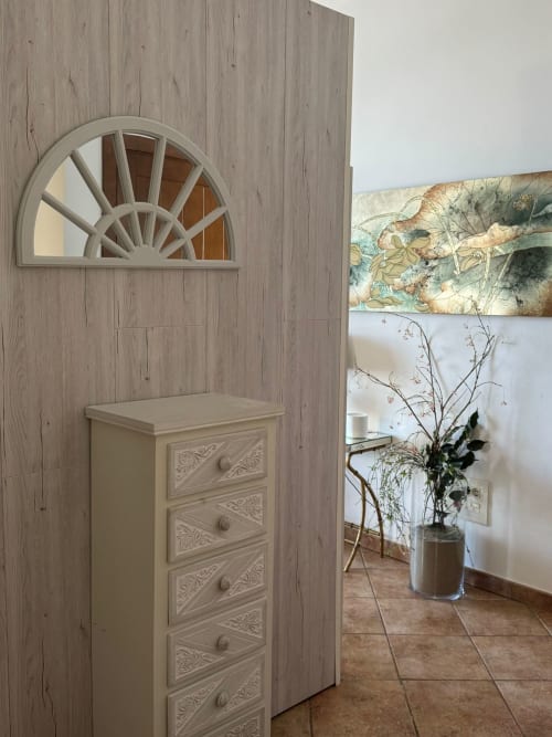 Elegante pasillo del apartamento Solpor Baiona con cómoda decorativa y ventana semicircular