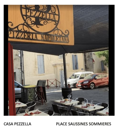 Casa Pezzella pizzeria outdoor terrace with tables and awning at Place Saussines Sommieres