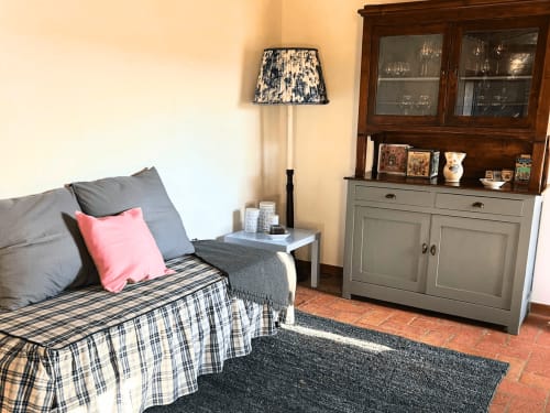 Camera accogliente dell'appartamento Il Granaio, B&B Torre Della Chiocciola Monteriggioni, con biancheria scozzese, cuscino rosa e legno