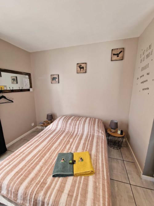 Chambre du studio Le Loup à Lamotte-Beuvron avec lit double, décoration nature et linge de maison fourni, offrant confort et ambiance chaleureuse pour un séjour en Sologne.