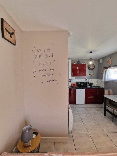 Studio Le Loup, gîte Lamotte-Beuvron en Sologne, avec coin nuit cosy, table de chevet et vue sur la cuisine équipée moderne, idéal pour un séjour chaleureux et indépendant.