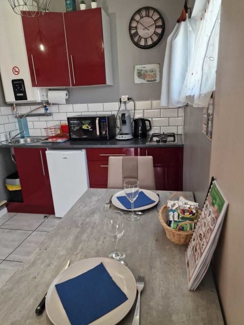 Coin cuisine du studio Le Loup à Lamotte-Beuvron avec table dressée pour deux personnes, kitchenette équipée et décoration moderne.