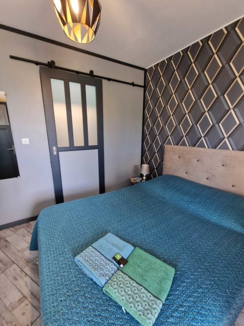 Chambre du studio Le Jardin, gîte Lamotte-Beuvron en Sologne, avec lit double, linge de maison fourni et décoration moderne pour un séjour confortable.