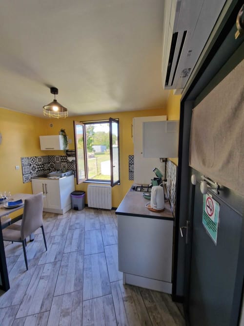 Cuisine équipée du studio Le Jardin, gîte Lamotte-Beuvron en Sologne, avec climatisation, coin repas et accès direct au jardin pour un séjour agréable et indépendant.