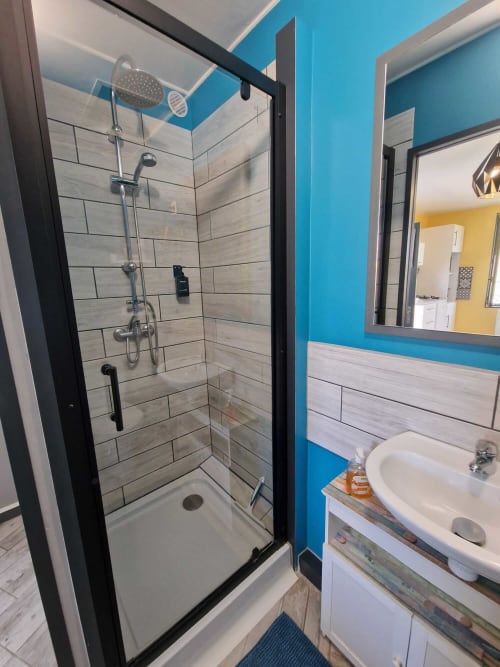 Salle de douche du studio Le Jardin, gîte Lamotte-Beuvron en Sologne, avec cabine moderne, vasque et miroir pour un séjour pratique et confortable.