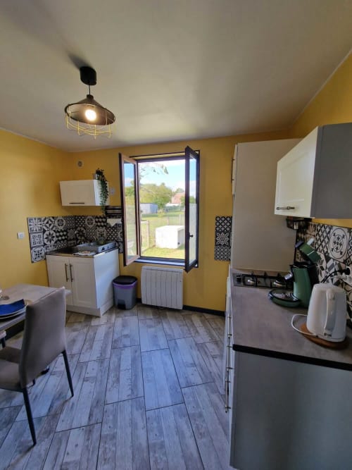Cuisine lumineuse du studio Le Jardin, gîte Lamotte-Beuvron en Sologne, avec plaques de cuisson, évier, machine à café et accès direct au jardin.