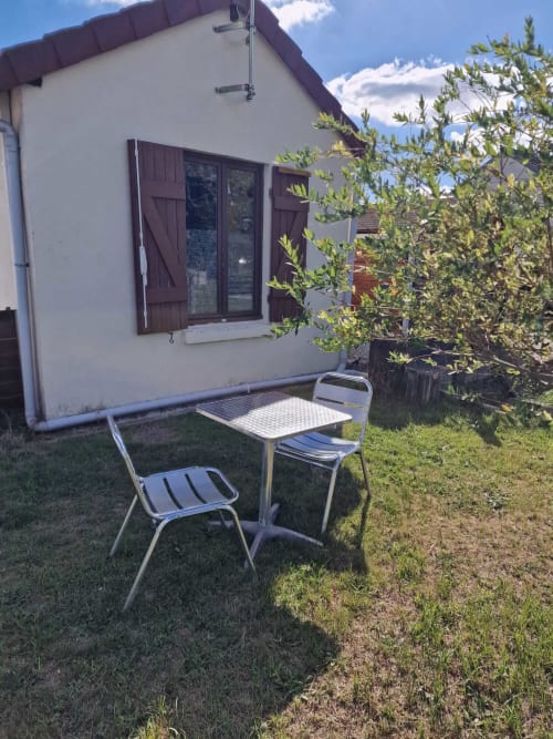 Coin repas extérieur du studio Le Jardin, gîte Lamotte-Beuvron en Sologne, avec table et chaises de jardin pour profiter des beaux jours en plein air.