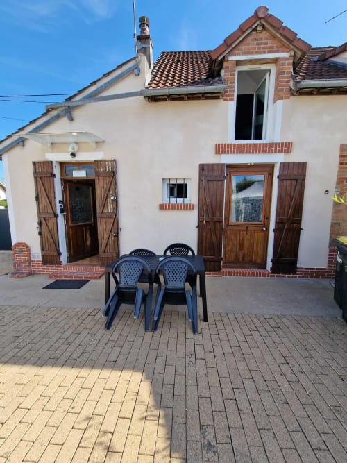 Cour extérieure du gîte Harmonie à Lamotte-Beuvron avec table et chaises, idéale pour profiter des repas en plein air lors d’un séjour en Sologne.