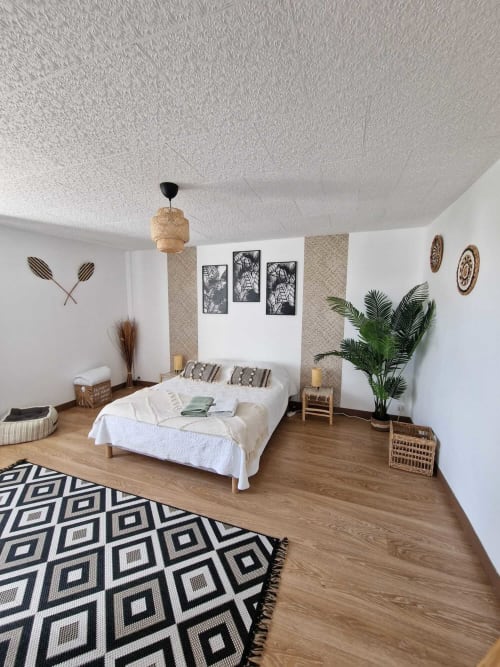 Grande chambre parentale du gîte Harmonie à Lamotte-Beuvron, décoration bohème chic avec lit double, tapis géométrique et plantes vertes, idéal pour un séjour en Sologne