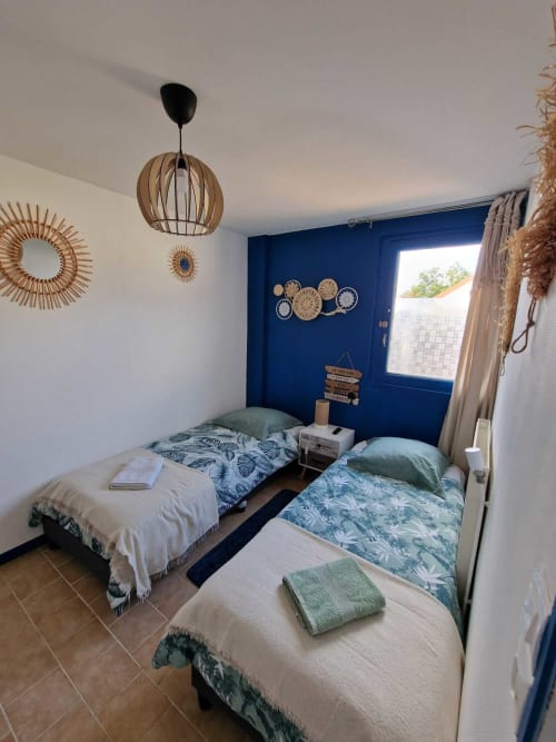 Chambre du gîte Harmonie à Lamotte-Beuvron en Sologne, avec deux lits simples, décoration bohème et ambiance cosy, idéale pour un séjour en famille ou entre amis.