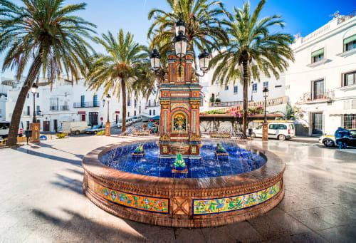 Fuente ornamentada con azulejos y palmeras en la plaza de Medina Sidonia en La Vista Medina Stays