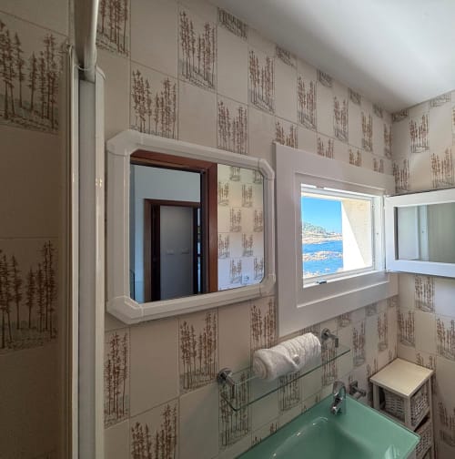 Baño moderno en  Albatros Dúplex de Holibai, Baiona, con vistas al mar, espejo, lavamanos y ventanal costero