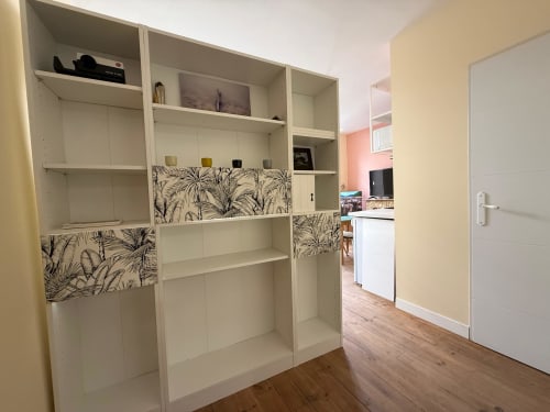 Modernes Studio in Lourdes mit weißem Regal, botanischen Schubladenfronten, Holzboden und Küche
