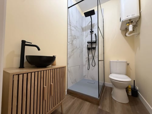Modernes Badezimmer mit schwarzem Aufsatzwaschbecken, begehbarer Dusche und Toilette im Hotel Ombre de la Tour in Lourdes