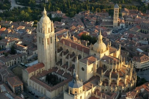 Vista aérea de la Catedral de Segovia con cúpulas doradas y tejados de terracota, cerca del hotel rural Nieva