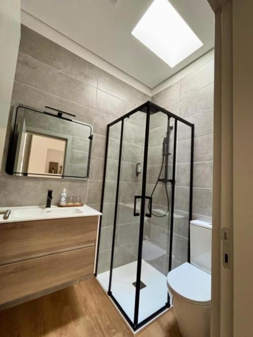 Modern bathroom in Malvasia room at Casa Tawny, Pinhão with skylight, black-framed shower enclosure, and wooden vanity