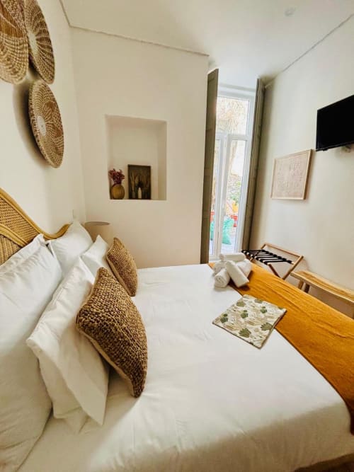Cozy double bedroom at Casa Tawny in Pinhão with white bedding, woven pillows, wooden desk, and modern amenities