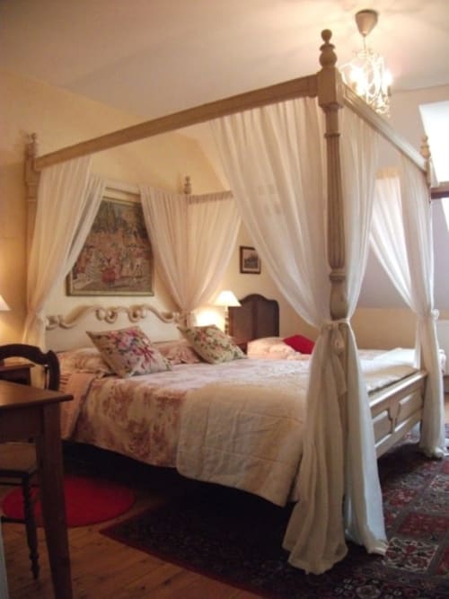 Élégant lit à baldaquin avec rideaux crème à la Chambre du Parc du Château de Bellevue, Sainte-Cécile, France