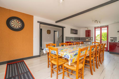 Salle à manger lumineuse avec chaises et table orange à Vacances en Touraine, Souvigny-de-Touraine, avec fléchettes et rouge