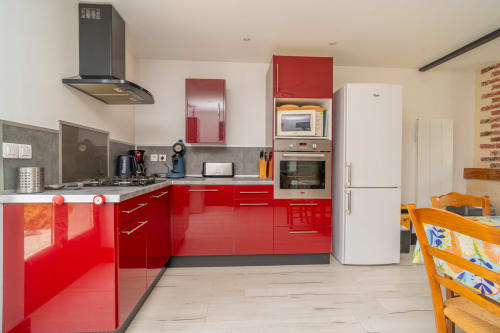 Cuisine moderne rouge avec électroménagers en acier inoxydable à Vacances en Touraine, Souvigny-de-Touraine
