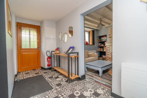 Entrée de Vacances en Touraine avec porte en bois, sol à motifs, équipements de fitness et séjour ouvert