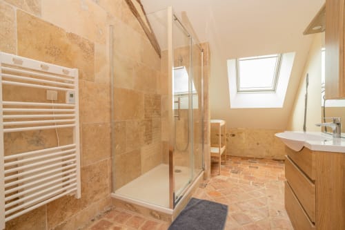 Salle de bains spacieuse à Vacances en Touraine avec douche à l'italienne, sèche-serviettes chauffant et puits de lumière à Souvigny-de-Touraine