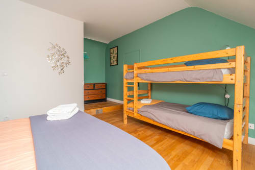 Chambre lumineuse à l'auberge Vacances en Touraine avec lit superposé, lit simple, mobilier en bois et murs verts
