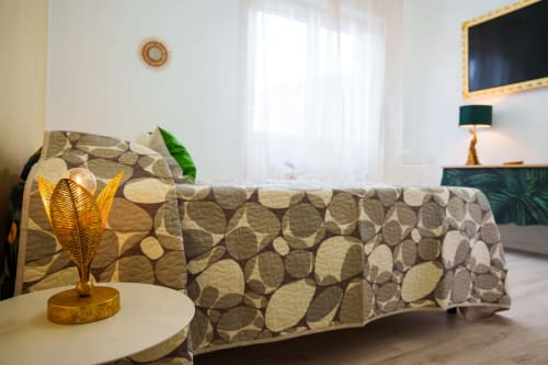 Cozy bedroom at Navigli Affittacamere B&B in Rozzano with patterned sofa, gold decor, and natural light