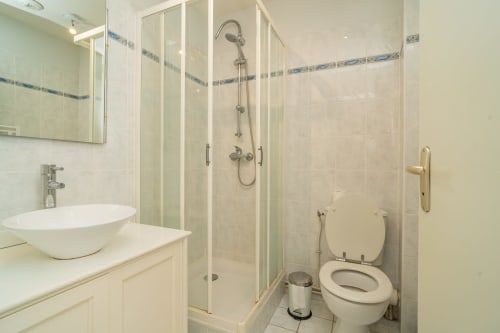Salle de bain moderne avec vasque blanche, douche vitrée et toilettes à l'hôtel Vacances en Touraine