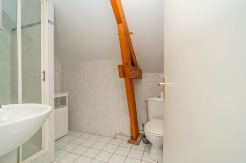 Salle de bain à Vacances en Touraine avec baignoire, toilettes et poutre en bois