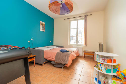 Chambre d'enfant colorée au gîte Vacances en Touraine avec mur turquoise, lit, jouets et lumière naturelle