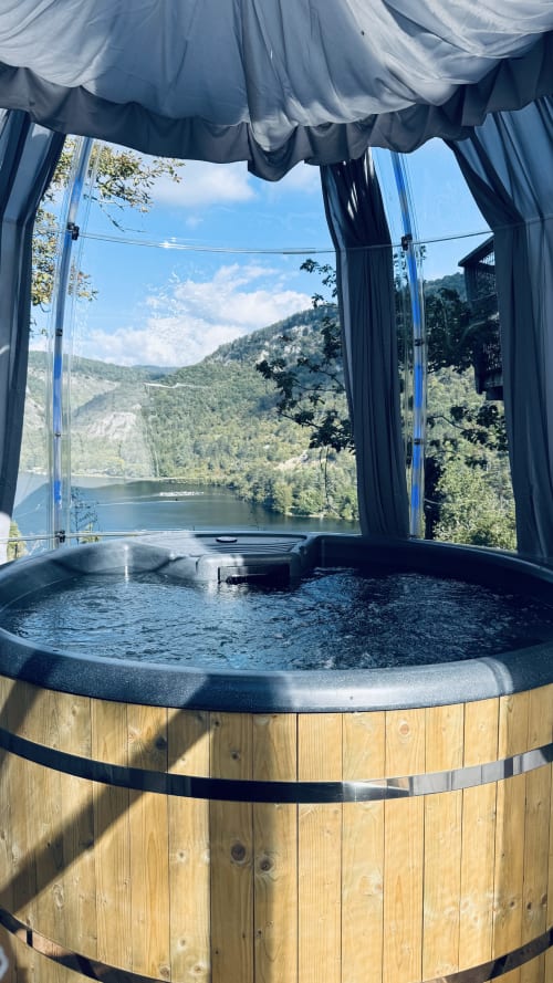 Wooden hot tub with panoramic views of Ain River and forested mountains at Cabanes et lodges du Belvédère, Serrières-sur-Ain
