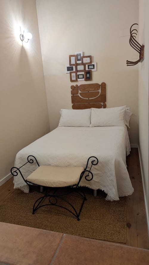 Acogedora habitación en Villas Vacacionales Sevilla, Salteras, con ropa de cama blanca, cabecero de madera, arte decorativo y detalles ornamentales