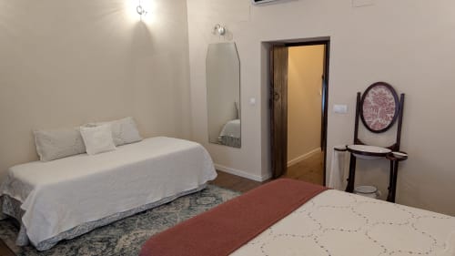 Amplio dormitorio en Villas Vacacionales Sevilla, Salteras, con dos camas, espejo, tocador y decoración neutral