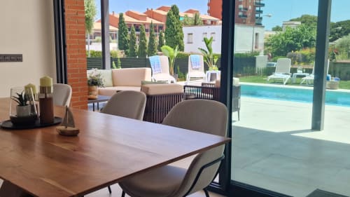 Comedor de villa de lujo en Benicàssim con mesa de madera, vistas al jardín y acceso a piscina a través de ventanales