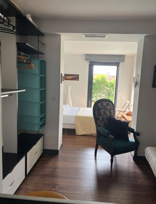 Modern villa bedroom at La Conciergerie De Franck with teal accents, sitting area, and pool view