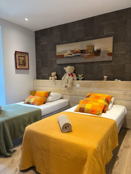 Colorful children's bedroom at La Conciergerie De Franck villa in Boissieres with twin beds, teddy bears, and modern dark