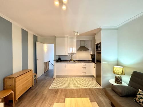 Moderno apartamento diáfano en Sabaris, Baiona con cocina blanca, muebles de madera y sala de estar