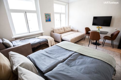 Modern living room with sofa bed & Kairo's colorful street art. Central Tartu accommodation near Raekoja Square, RIMI & MyFitness. WiFi & AC