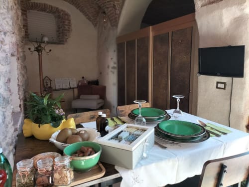 Dining table setup at CasaRosada B&B in Vidracco with green plates, fresh ingredients, and rustic Italian ambiance