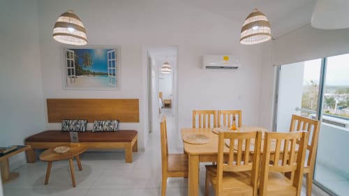 Sala de estar moderna en Olamar Living con comedor, muebles de madera y vistas costeras en Coveñas, Colombia