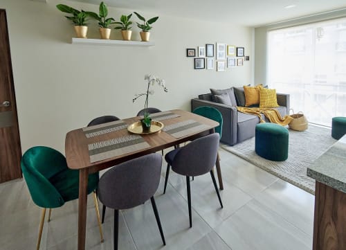 Moderno departamento en CDMX en Pares Homes con comedor, sofá gris, acentos verde azulado, plantas en maceta y vistas a la ciudad