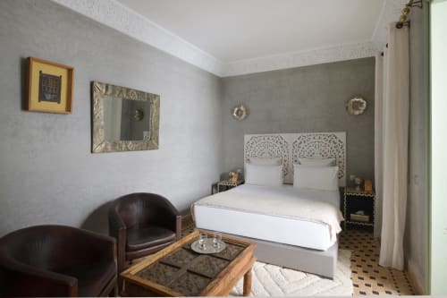Chambre Royale in Riad Palau Marrakech met wit uitgesneden bed, lederen fauteuils en grijze accentmuur